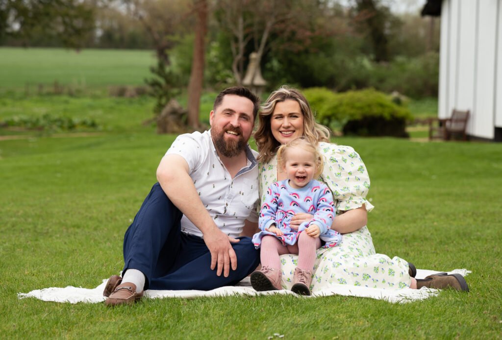 Family of three Family of 3 sitting on a rug