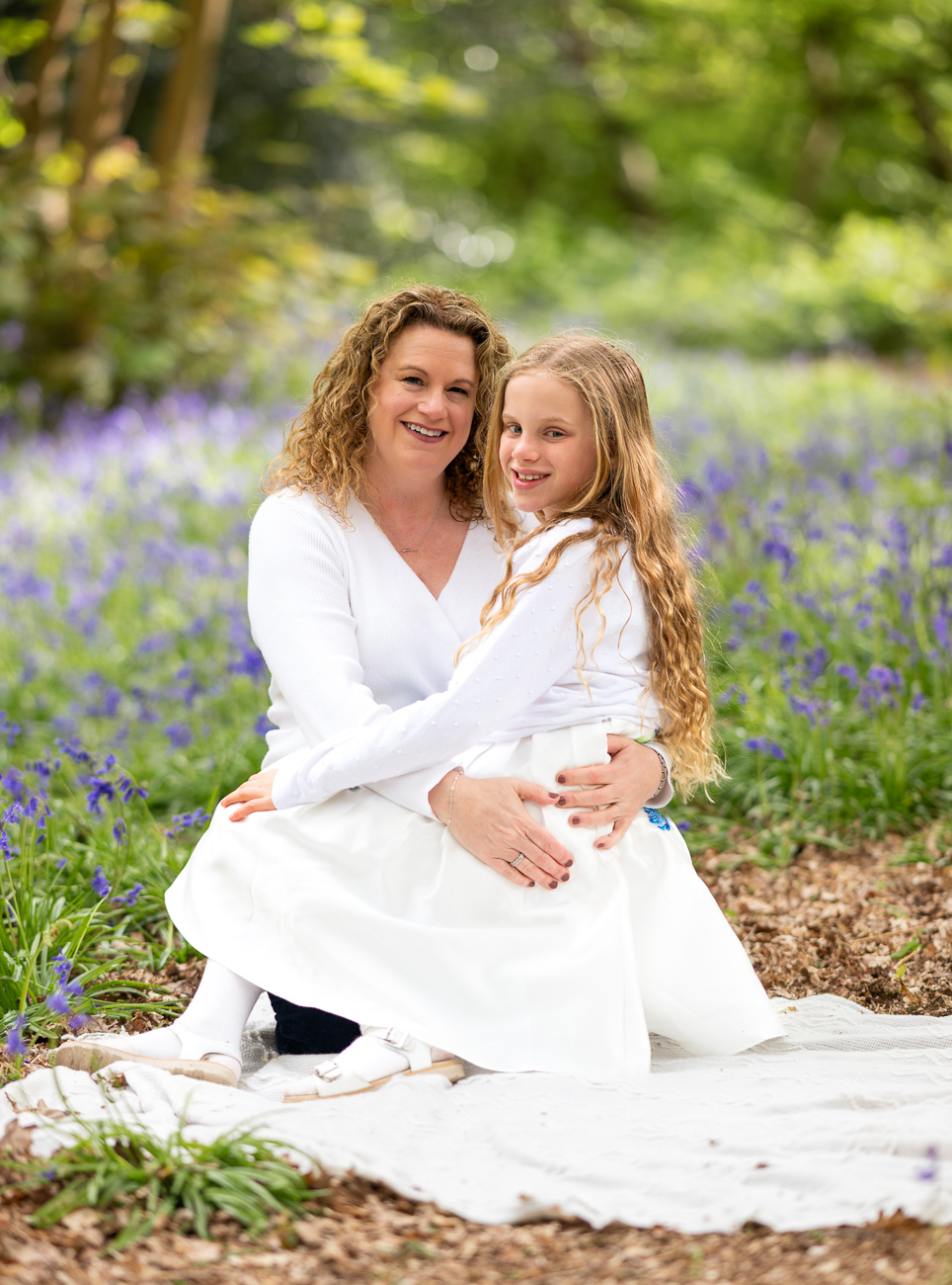 Mother and daughter sitting in the bluebell wood