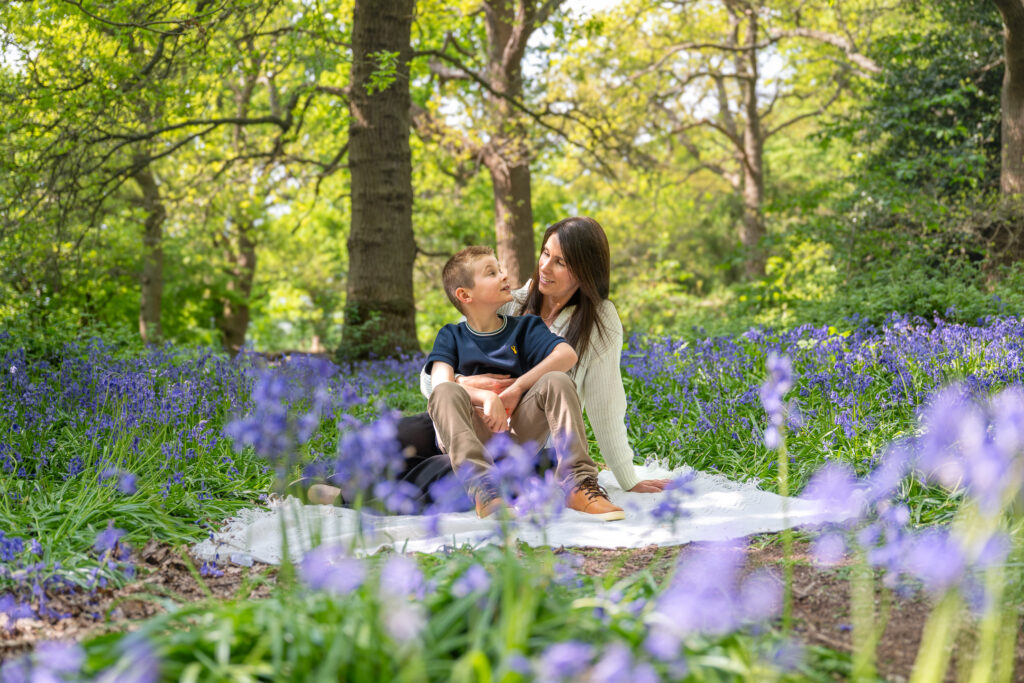 Mother and son sitting in the bluebell woods