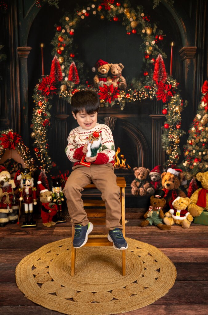 Boy on a stepladder next to a fireplace smiling and holding a book