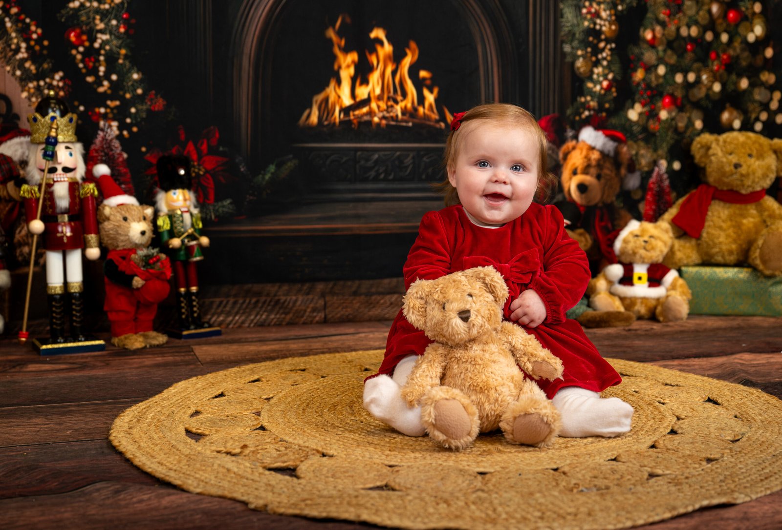 Toddler with a teddy smiling at the camera having her photo taken