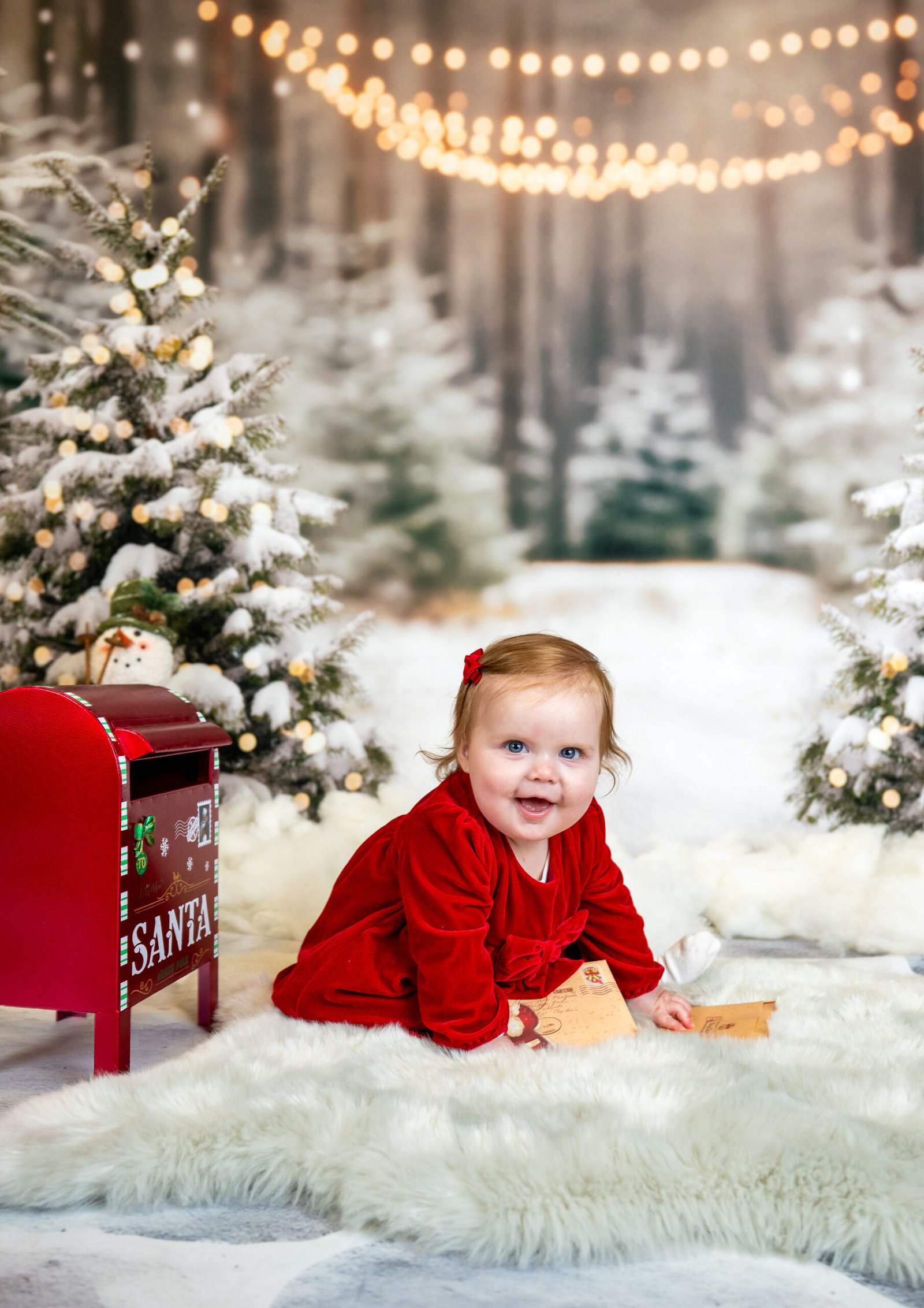 Toddler crawling and smiling posting letters in the snow