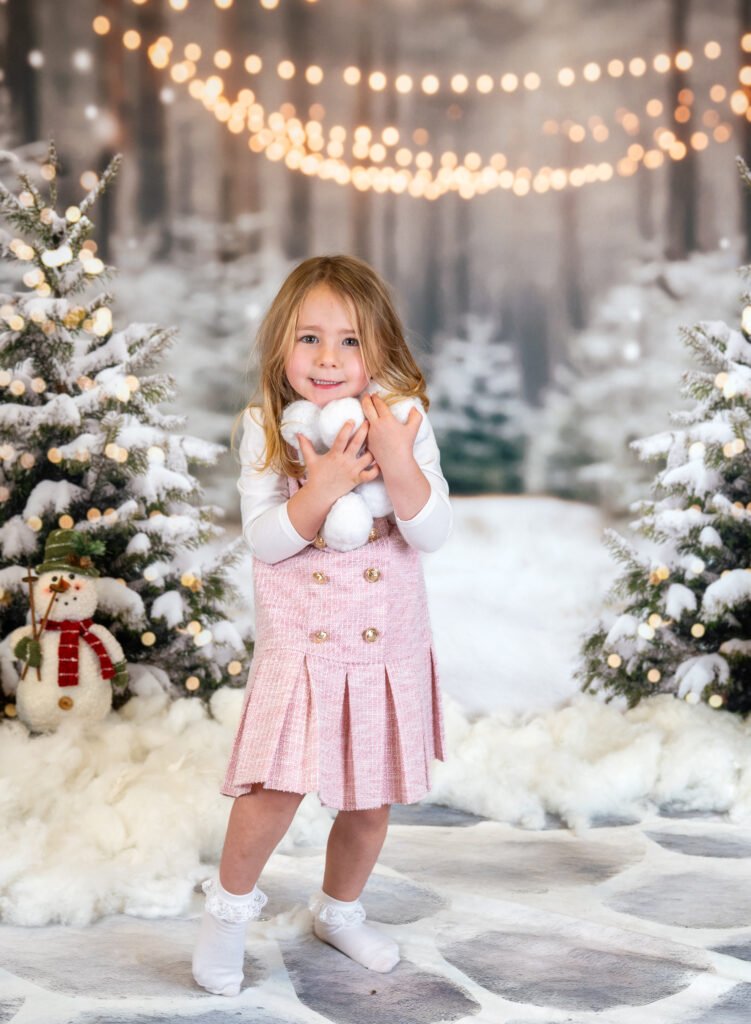 Girl standing up with handfuls of snowballs