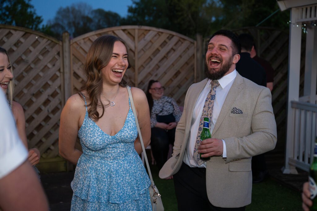 Couple laughing outside at a party